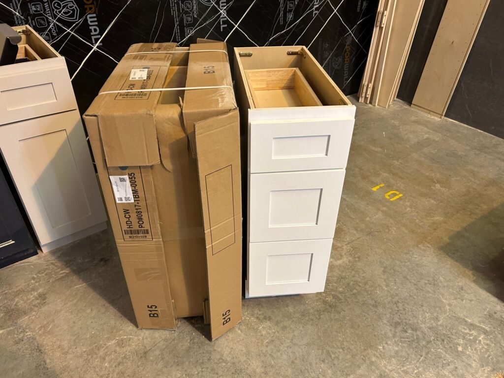 RTA cabinet box next to an assembled drawer base with the drawer open