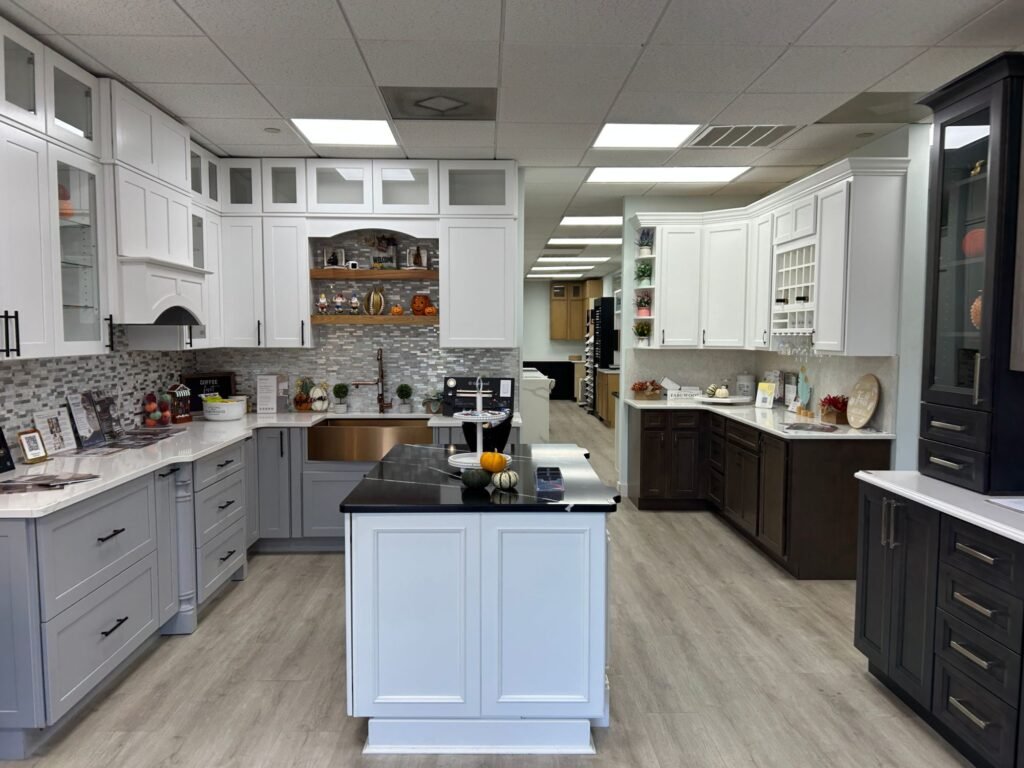 Kitchen cabinet displays on the Land of Cabinets showroom floor in Richmond, VA, with gray, white and espresso cabinets around a black-top island