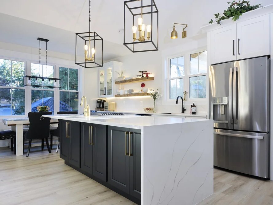 White Timberpeak kitchen with a black island and waterfall countertop